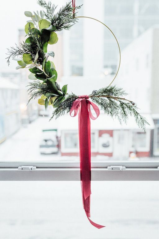 a simple and modern Christmas wreath with evergreens and greenery and a red ribbon bow is a catchy idea