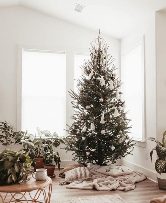 a simple boho Christmas tree with silver and other metallic ornaments plus a large white tassel garland