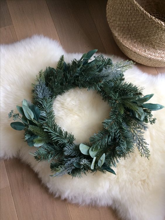 a simple modern Christmas wreath of evergreens and leaves is a catchy and stylish idea for the holidays