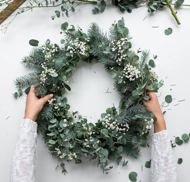 a stylish modern Christmas wreath of evergreens, eucalyptus and baby's breath is a beautiful and textural idea