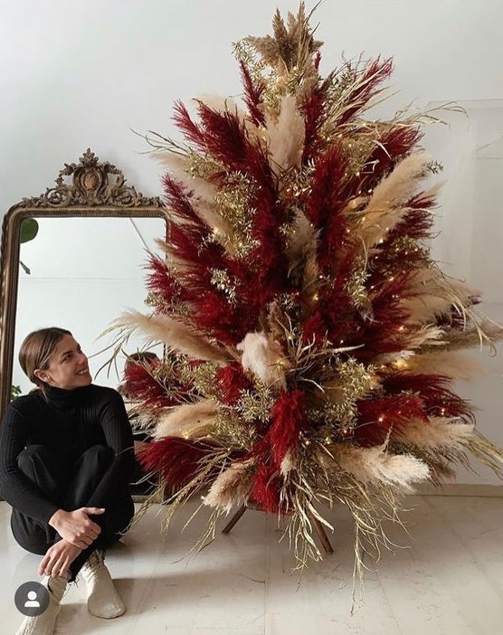 a super bold neutral and burgundy pampas grass Christmas tree decorated with gilded branches and lights is cool for the holidays