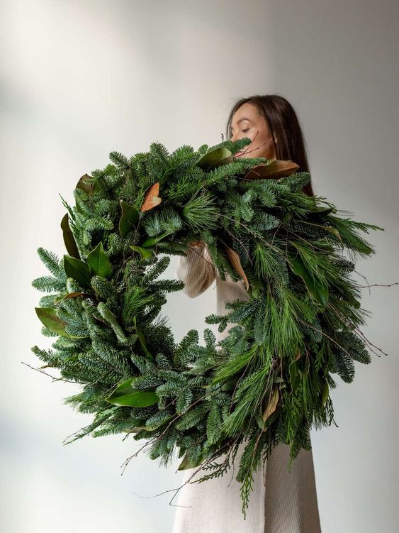 a super lush and bold modern Christmas wreath of evergreens, leaves and grasses plus twgis is amazing and beautiful