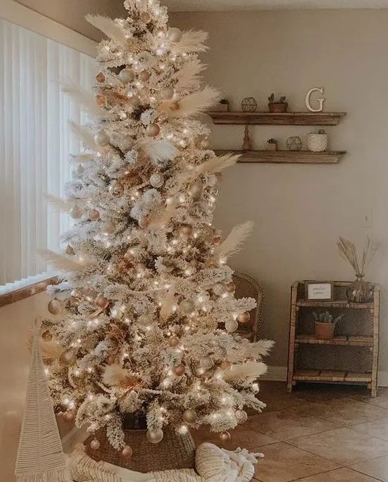 an amazing neutral boho Christmas tree decorated with pampas grass, gold and metallic ornaments, white ones and lights