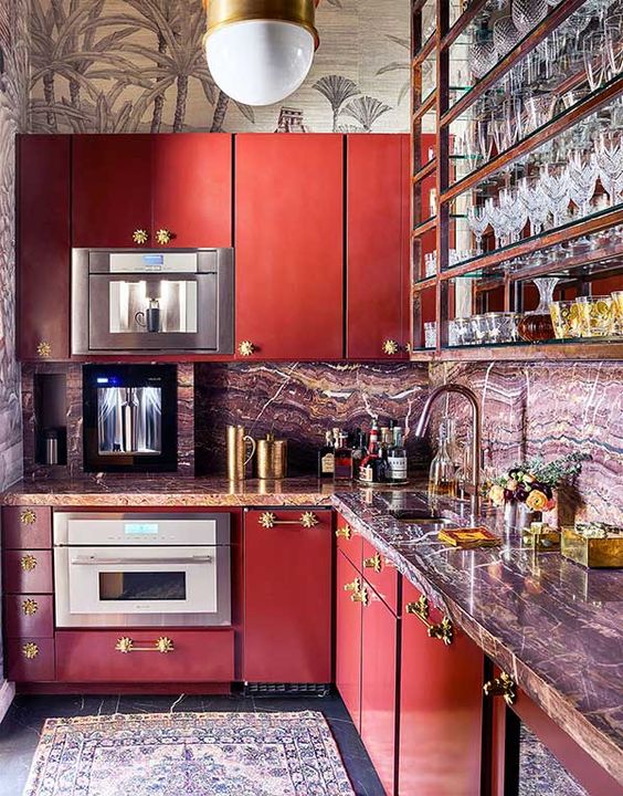 a fantastic vintage red kitchen with stone countertops and a backsplash, open shelves, chic fixtures and pendant lamps