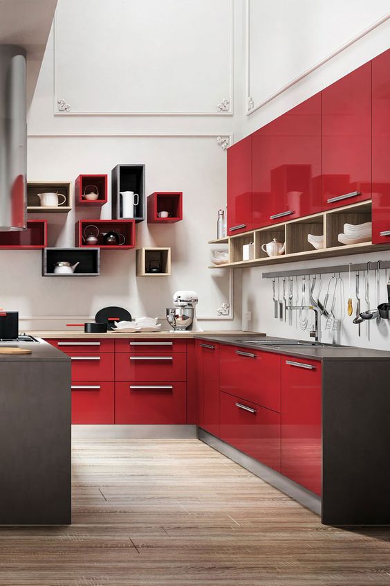 a glossy red kitchen with grey countertops, a white backsplash and eye-catchy colorful box shelves