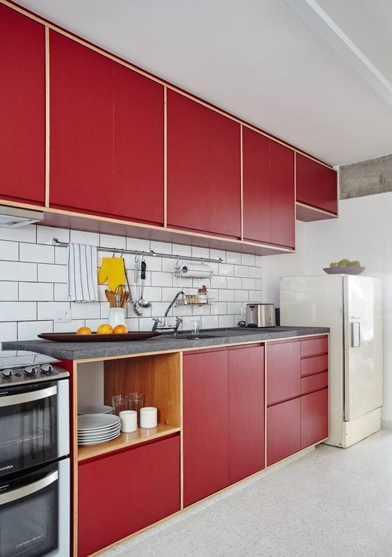 a modern red kitchen with a white subway tile backsplash, grey stone countertops, open shelves is a catchy space