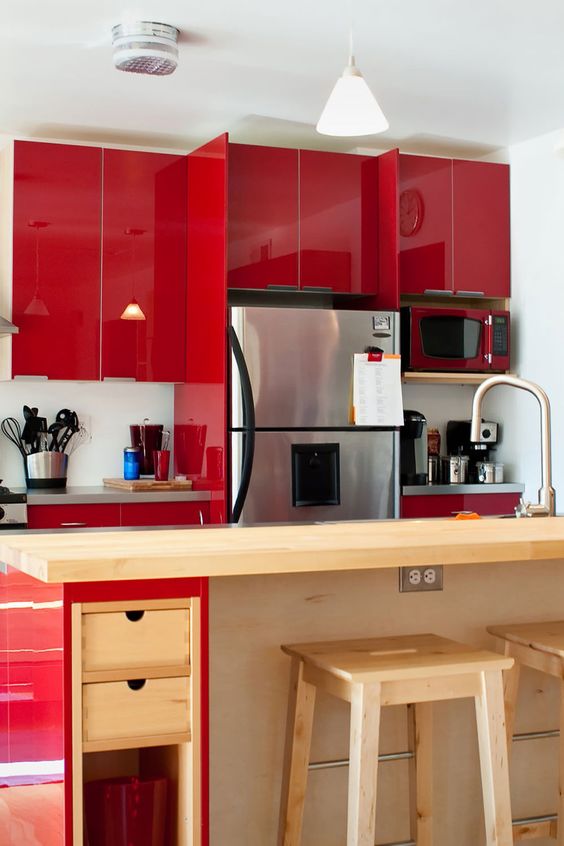 an extra bright red kitchen with glossy panels, a red and stained kitchen island, grey countertops