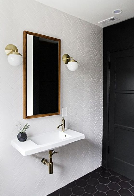 white skinny tiles in a cheveron pattern paired with black hexagon tiles on the floor for a chic bathroom look