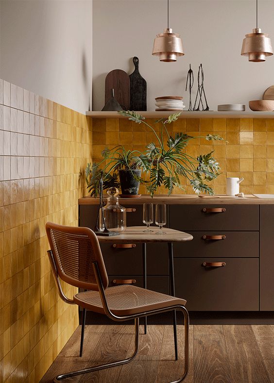 a beautiful vintage kitchen with dark green cabinets, a bold yellow Zellige tile backsplash, an open shelf and pendant lamps