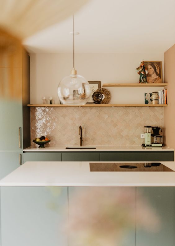 a chic green kitchen with white countertops and a tan Zellige fish scale tile backsplash and open shelves