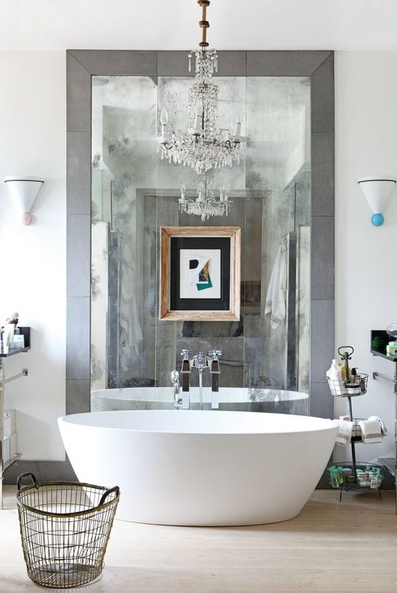 a-contemporary-bathroom-in-neutral-shades-an-oval-tub-a-large-mirror-in-tiles-a-crystal-chandelier.jpg