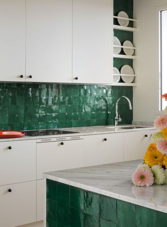 a contrasting kitchen with white cabinets, white stone countertops, a green Zellige tile backsplash and accent on the kitchen island