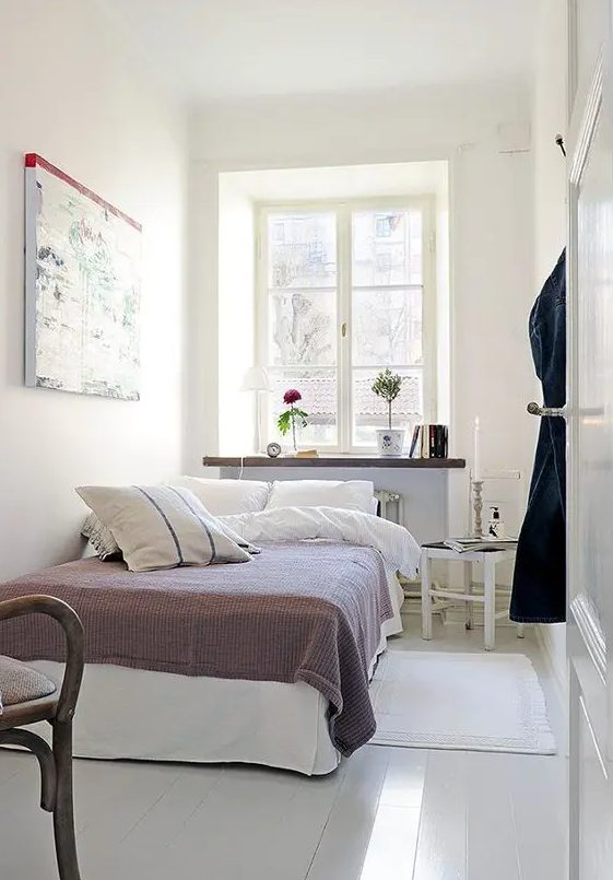 a narrow Scandinavian bedroom with a bed, a windowsill as a storage unit, a stool as a nightstand and some decor