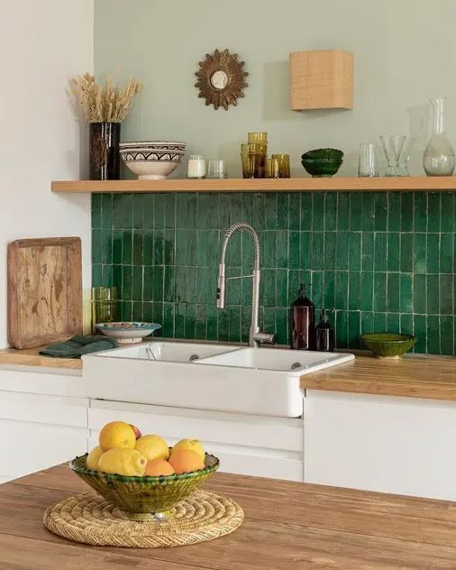 a neutral serene kitchen with a stacked green Zellige tile backsplash, an open shelf and some lovely decor