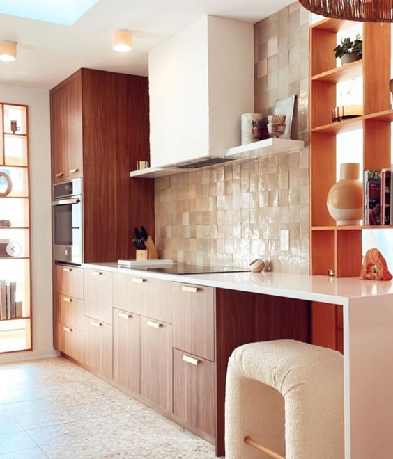 a rich-stained kitchen with a tan Zellige tile backsplash, white countertops, a white hood and a lovely bent stool