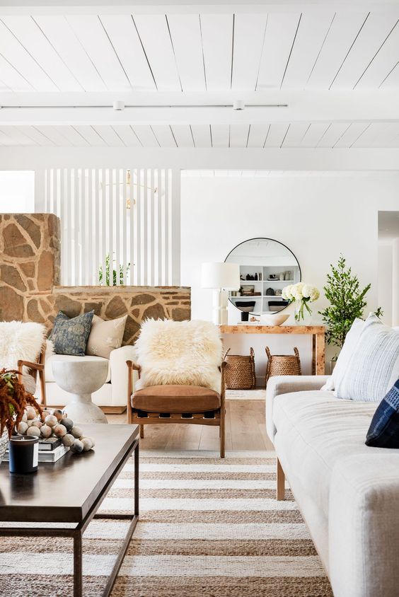 a-welcoming-neutral-living-room-with-a-sofa-rust-chairs-a-striped-rug-a-coffee-table-some-decor-and-a-console-table-with-decor.jpg
