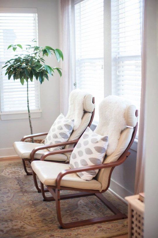 white Poang chair with printed cushions and fur covers
