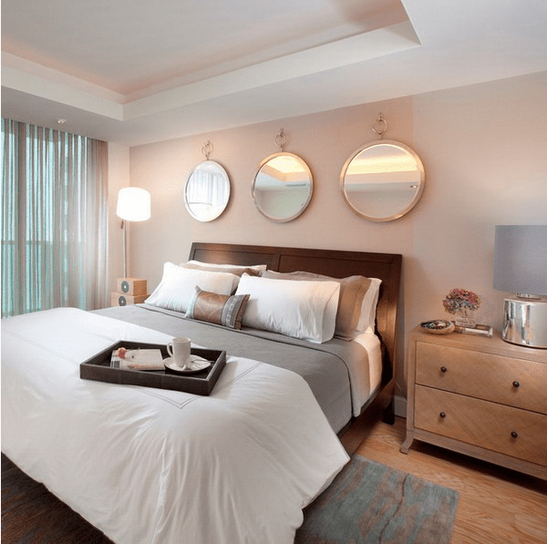 identical round mirrors above the bed