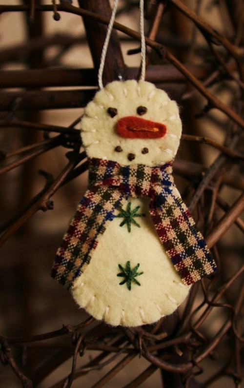 a white felt snowman Christmas ornament with a plaid scarf embroidery and beading is a lovely bold decoration idea