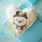 a white felt heart-shaped Christmas ornament with a painted snowman is a lovely and cool idea for holiday decor