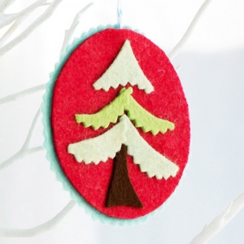 a red felt Christmas ornament with a tree of felt is a non-typical and cute idea of a decoration that you can make yourself