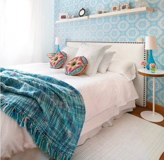 a duo of horizontal shelves over the bed and lots of neutrals make the bedroom look larger and more welcoming