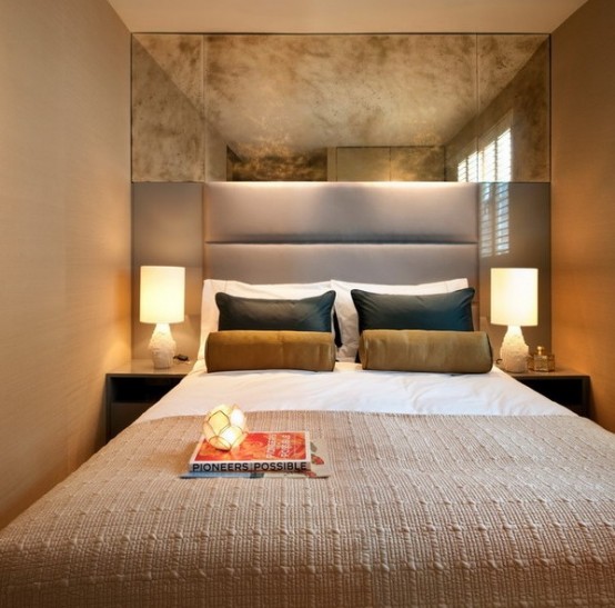 horizontal panels and a vintage mirror over the bed make the small bedroom look larger and cooler
