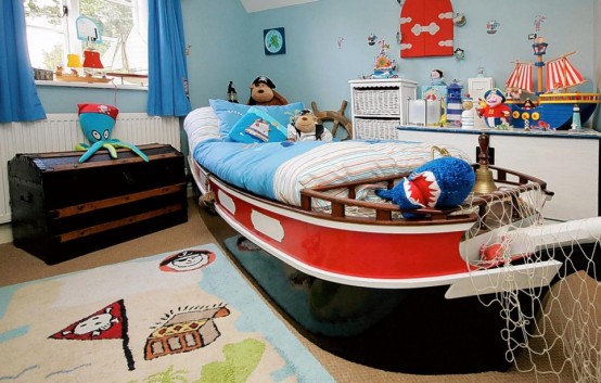 a sea-inspired boy's room done with a ship bed, lots of ship decor, toy sea creatures and even a pirate rug