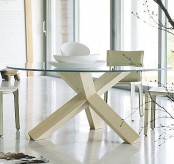 a Scandinavian dining table with a glass tabletop and whietwashed wooden beam legs is a stylish idea for a Scandinavian dining room