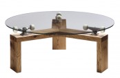 a creative industrial round dining table with a round glass tabletop, a wooden base and some metal constructions that hold the tabletop