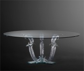 a unique and sophisticated dining table with an oval glass tabletop and beautiful and refined shaped metal legs is a chic and cool idea