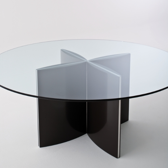 a modern dining table with a round tabletop and a black metal base of four petals looks eye catchy and lightweight, the base is accented