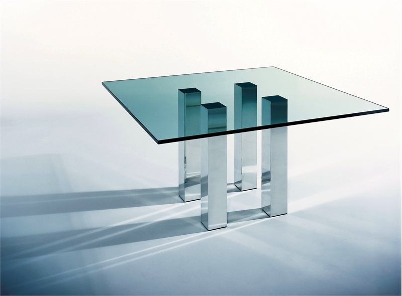 an ultra modern dining table with a glass tabletop and metal legs as pillars is a stylish idea for a modern or minimalist dining room