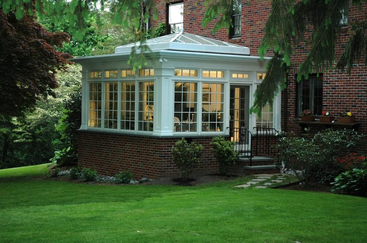a conservatory externsion that features a cool pyramid-shaped glass roof