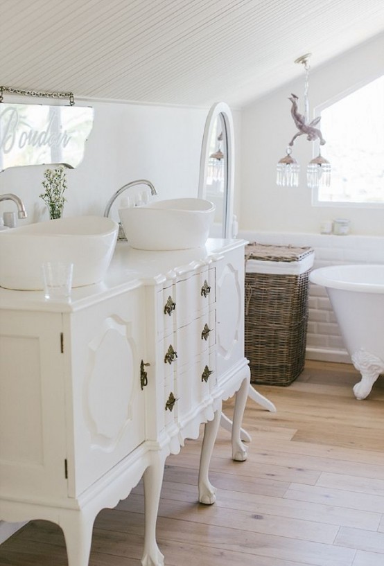a creamy Provence bathroom with a vintage clawfoot bathtub, a vintage and refined white vanity, a mirror, a pendant crystal lamp