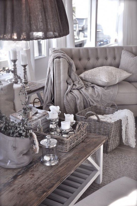 a grey shabby chic living room with refined furniture, a low coffee table, a basket tray and a basket for storage plus elegant candleholders