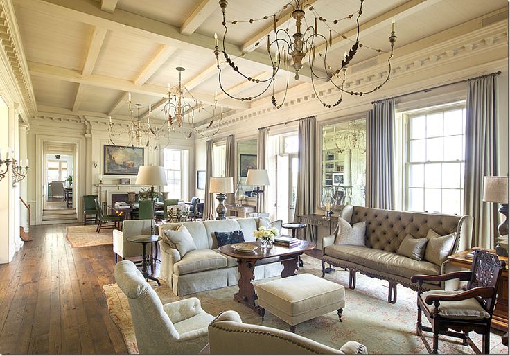 a neutral Provence living room with chandeliers, refined furniture, floor lamps