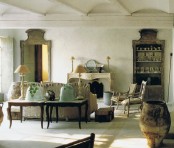 a neutral Provence living room with a faux fireplace, neutral furniture, coffee tables, chic table lamps