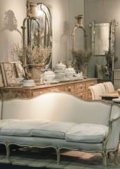 an adorable Provence living room with a shabby chic sideboard, vintage furniture, mirrors and dried floral arrangements
