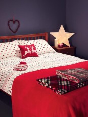 red and white bedding, plaid blankets and a marquee star as a lamp for a Christmas bedroom