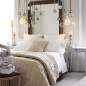 a neutral Christmas bedroom with a vintage chair with a gift box stack and lots of ornaments hanging over the bed