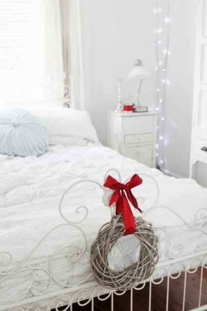 white lights on branches, a mini vine wreath with a red bow bring a holiday feel to the space