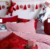 a bright red and white Christmas bedroom with a paper bunting, red and striped bedding plus a holiday pillow