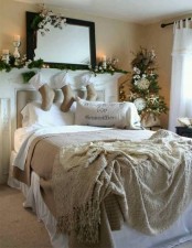 a neutral Christmas bedroom with evergreens, white blooms and cotton, candles and vintage-inspired bedding with ruffles and a crochet blanket