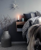 some faux fur, a star ornament and branches in a vase for a grey Christmas bedroom