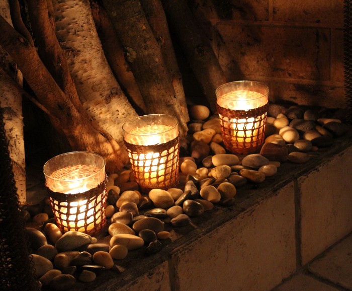 a tray with pebbles and glass candle holders with candles for a natural touch