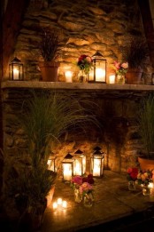 candle lanterns on the mantel and in the fireplace, much greenery and blooms for beautiful decor