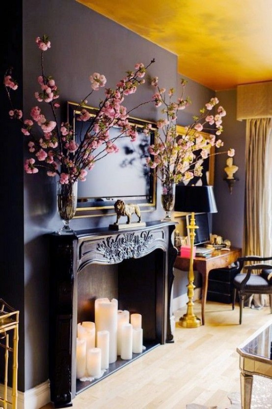 a large refined black fireplace with large pillar candles that create a bold contrast with the fireplace itself