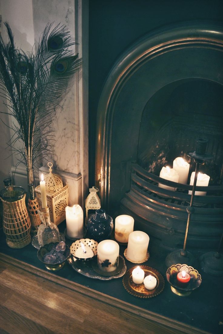 some candles in the fireplace and on small trays and plates next to it for a boho feel