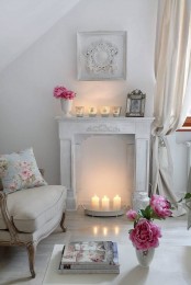 a romantic vintage whitewashed fireplace with a small metal tray with three candles